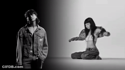 A Black And White Photo Of A Man In A Denim Jacket And A Woman In A Bra GIF
