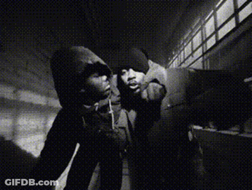 A Black And White Photo Of A Man In A Hoodie Smoking A Cigarette GIF