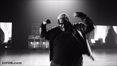 A Black And White Photo Of A Man In A Jacket Dancing GIF