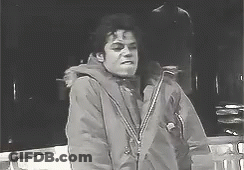 A Black And White Photo Of A Man In A Jacket Standing Next To A Railing . GIF