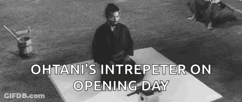 A Black And White Photo Of A Man In A Kimono Sitting On A White Surface . GIF