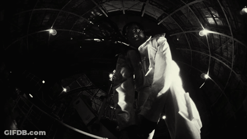 A Black And White Photo Of A Man In A Lab Coat With A Name Tag That Says ' A.j. ' On It GIF