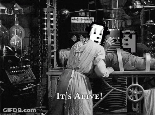 A Black And White Photo Of A Man In A Lab With The Words `` It 'S Alive '' On The Bottom . GIF