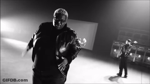 A Black And White Photo Of A Man In A Leather Jacket Dancing GIF