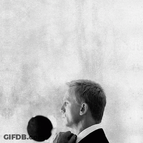 A Black And White Photo Of A Man In A Suit Adjusting His Tie GIF
