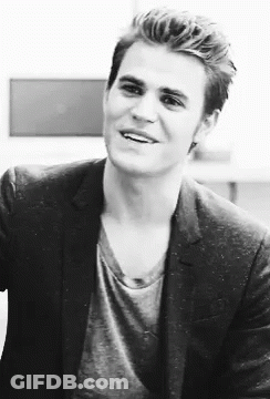A Black And White Photo Of A Man In A Suit And A Gray Shirt . GIF