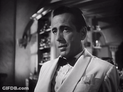 A Black And White Photo Of A Man In A Suit And Bow Tie GIF