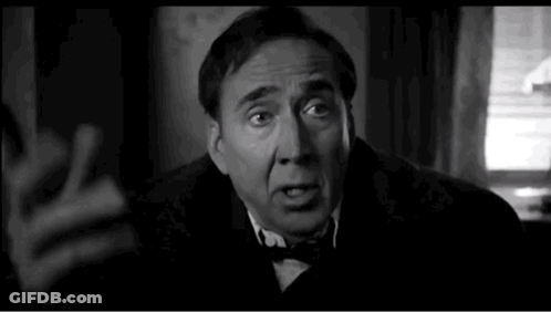 A Black And White Photo Of A Man In A Suit And Bow Tie Making A Funny Face . GIF