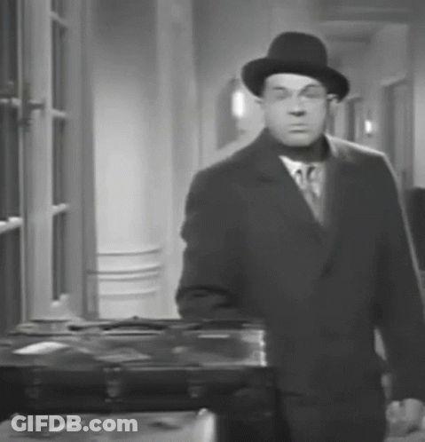 A Black And White Photo Of A Man In A Suit And Hat GIF