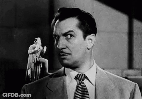 A Black And White Photo Of A Man In A Suit And Tie Holding A Statue . GIF
