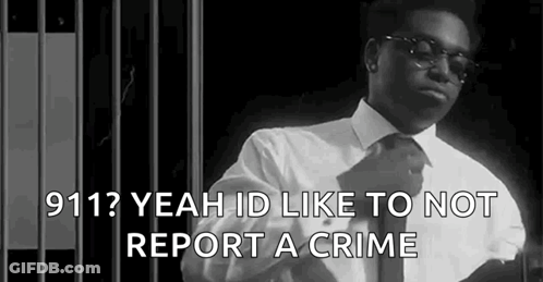 A Black And White Photo Of A Man In A Suit And Tie Standing In Front Of A Jail Cell . GIF