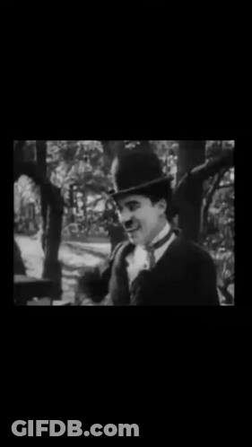A Black And White Photo Of A Man In A Suit And Top Hat . GIF