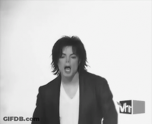 A Black And White Photo Of A Man In A Suit And White Shirt GIF