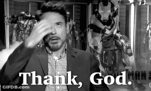 A Black And White Photo Of A Man In A Suit Covering His Face With His Hand And Saying `` Thank God '' . GIF