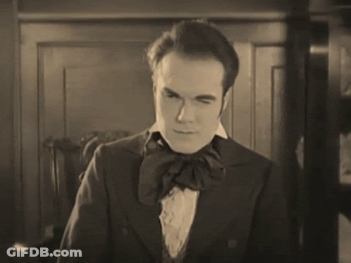 A Black And White Photo Of A Man In A Suit GIF