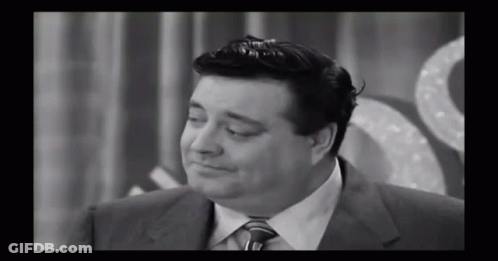 A Black And White Photo Of A Man In A Suit GIF