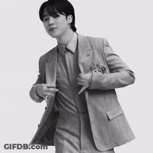 A Black And White Photo Of A Man In A Suit With His Jacket Open GIF