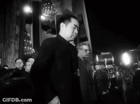 A Black And White Photo Of A Man In A Suit GIF