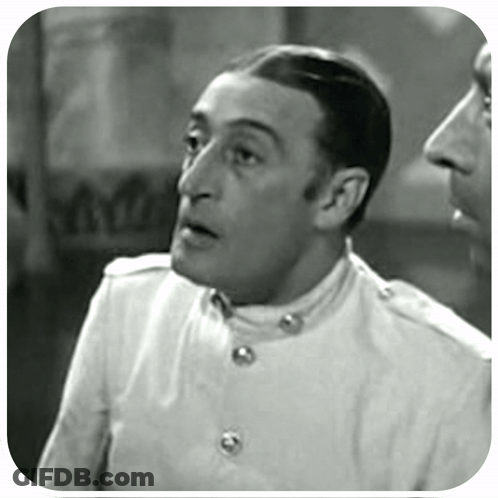 A Black And White Photo Of A Man In A White Jacket GIF