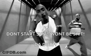 A Black And White Photo Of A Man In A White Shirt Dancing In A Hallway . GIF