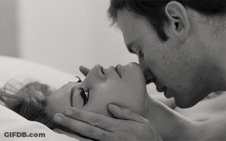A Black And White Photo Of A Man Kissing A Woman On The Forehead . GIF
