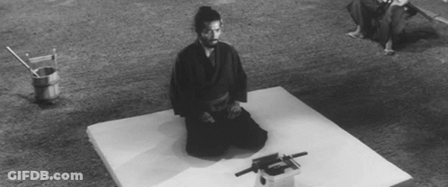 A Black And White Photo Of A Man Kneeling On A Mattress GIF