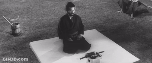 A Black And White Photo Of A Man Kneeling On A White Mat GIF