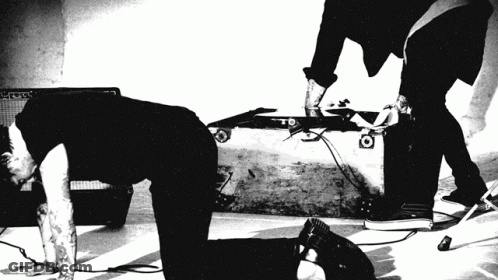 A Black And White Photo Of A Man Kneeling On The Floor GIF