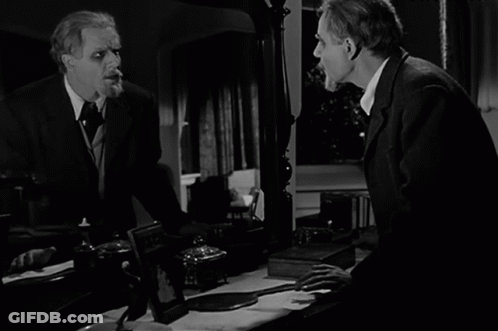 A Black And White Photo Of A Man Looking At Himself In The Mirror GIF