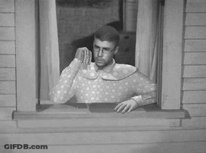 A Black And White Photo Of A Man Looking Out Of A Window With A Dollar Bill In His Hand GIF