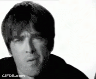 A Black And White Photo Of A Man Making A Funny Face With His Hand On His Chin . GIF
