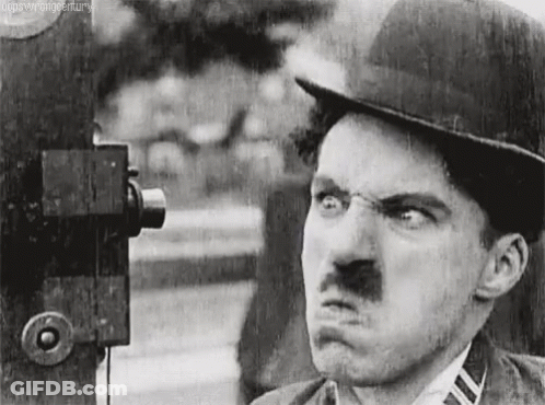 A Black And White Photo Of A Man Making A Funny Face . GIF