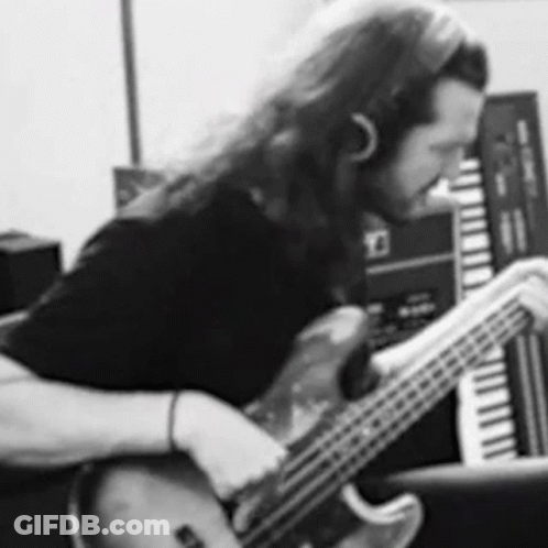A Black And White Photo Of A Man Playing A Bass Guitar In A Recording Studio . GIF