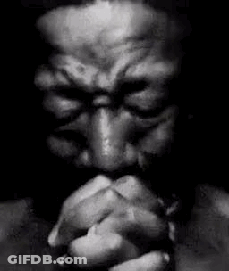 A Black And White Photo Of A Man Praying With His Eyes Closed . GIF