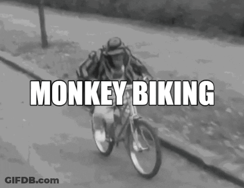 A Black And White Photo Of A Man Riding A Bicycle With The Words Monkey Biking Written Above Him GIF
