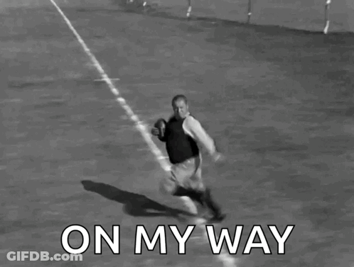 A Black And White Photo Of A Man Running With A Football With The Words On My Way Below Him GIF