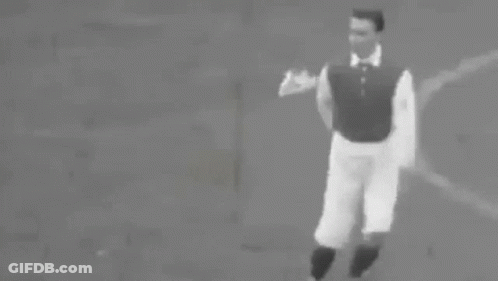 A Black And White Photo Of A Man Running With A Soccer Ball On A Field . GIF