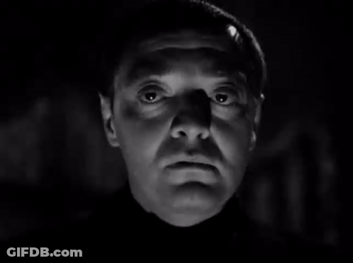 A Black And White Photo Of A Man 'S Face With A Shadow On His Forehead . GIF