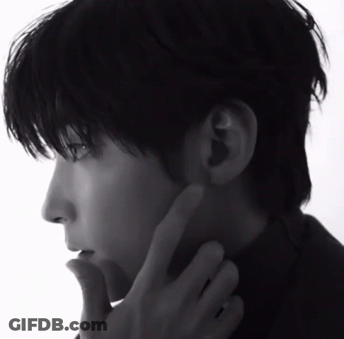 A Black And White Photo Of A Man 'S Face With His Hand On His Chin GIF
