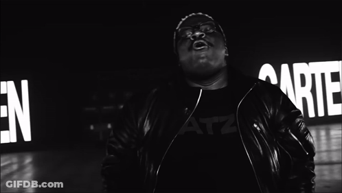 A Black And White Photo Of A Man Singing In Front Of A Sign That Says " Garten " GIF