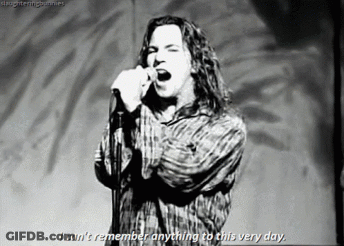A Black And White Photo Of A Man Singing Into A Microphone GIF