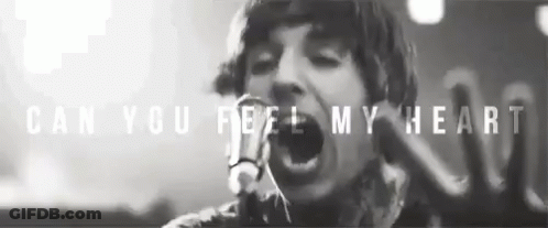 A Black And White Photo Of A Man Singing Into A Microphone With The Words Can You Feel My Heart Above Him GIF