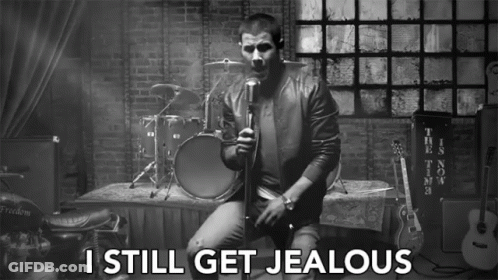 A Black And White Photo Of A Man Singing Into A Microphone With The Words I Still Get Jealous Below Him GIF