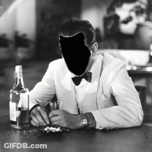 A Black And White Photo Of A Man Sitting At A Table GIF