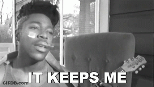 A Black And White Photo Of A Man Smoking A Cigarette With The Words " It Keeps Me " Below Him GIF