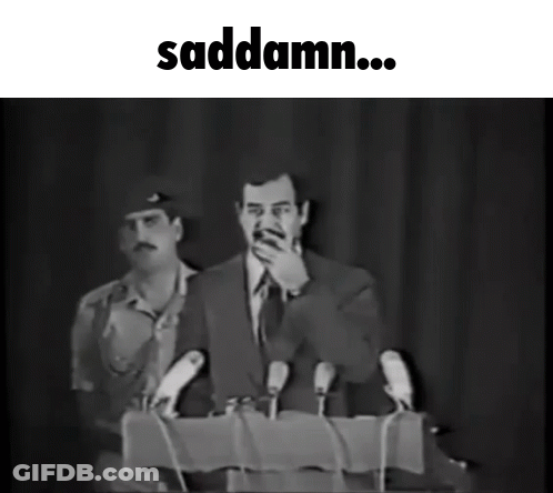 A Black And White Photo Of A Man Speaking Into Microphones With The Words Saddamn Below Him GIF