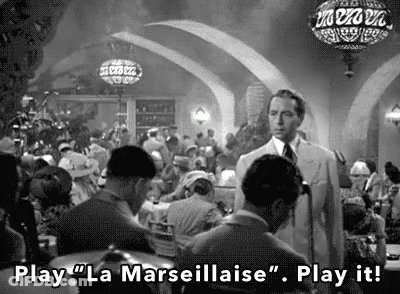 A Black And White Photo Of A Man Standing In A Crowded Restaurant . GIF