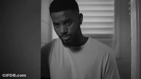 A Black And White Photo Of A Man Standing In A Doorway . GIF