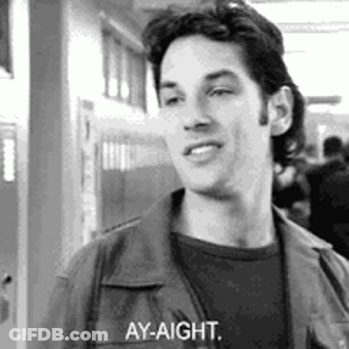 A Black And White Photo Of A Man Standing In A Hallway Talking To Someone . GIF