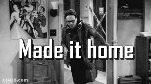 A Black And White Photo Of A Man Standing In A Hallway With The Words `` Made It Home '' Written On It . GIF